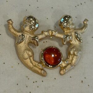New Vintage Louis Stern (LS) gold-tone cherub brooch with a faux amber cabochon.